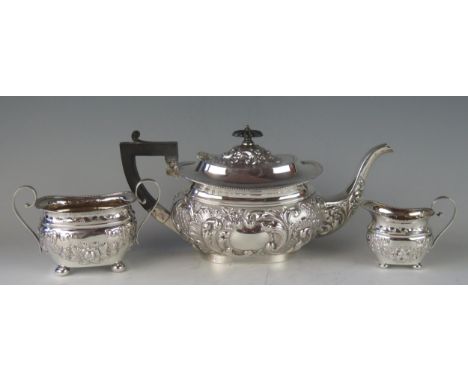 A matched three-piece barge-shaped silver tea service, various makers and dates, with gadrooned rims, embossed floral decorat