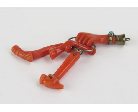 An Early 19th Century Coral Charm of a hand wearing a bracelet adorned with turquoise, holding a chain with a hammer, bugle a