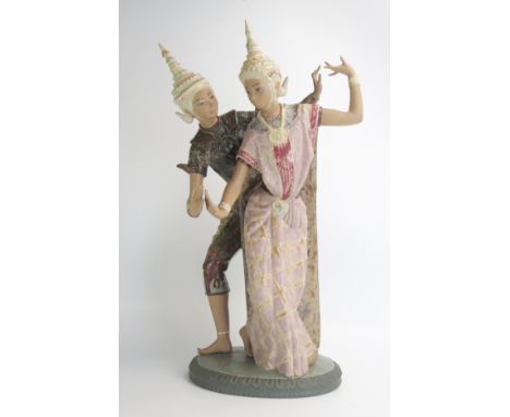 A large Lladro porcelain figure of two Siamese dancers, each in painted headdress, and on oval base, stamped to the underside
