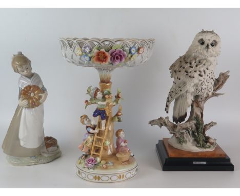 A Nao porcelain figure of a young girl with a pumpkin, a continental porcelain centrepiece, and a resin model of a snowy owl.