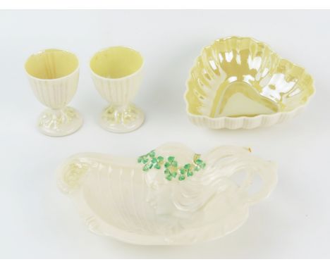A Belleek porcelain heart-shaped dish, two egg cups and an Art Nouveau influence dish of a maid playing an Irish harp. (4). 