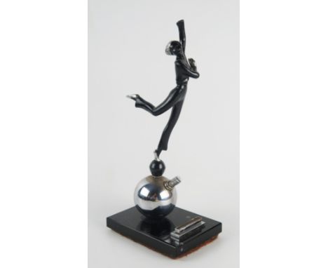 An Art Deco period figural table lighter, modelled as a dancing girl on a ball, mounted on a polished marble base, 22cm high.