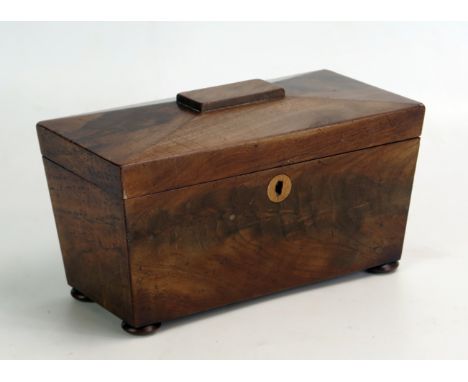 A 19th century mahogany tea caddy of sarcophagus outline with hinged lid, raised on squat bun feet, 23cm wide. 