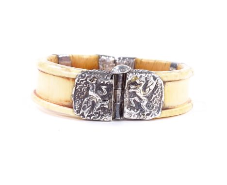 A 19th century African ivory and unmarked silver hinged bangle, relief dragon decoration, band width 17.7mm, internal diamete