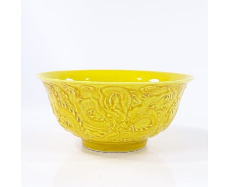 A Chinese yellow glaze porcelain bowl with relief moulded dragon designs, impressed seal mark, diameter 16cm 