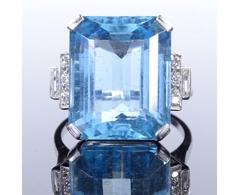 An Art Deco style large aquamarine and diamond dress ring, with round and baguette-cut stepped diamond shoulders and openwork