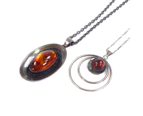 2 N.E. From Danish sterling silver and amber pendant necklaces, stylised form, circular pendant diameter 34mm, chain lengths 
