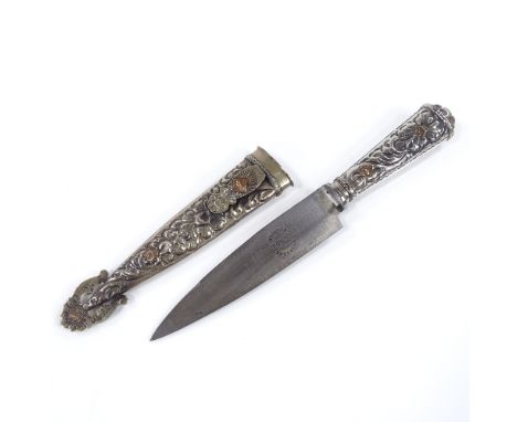 A white metal-cased Gaucho knife, with original scabbard and embossed floral decoration, overall length 22cm 