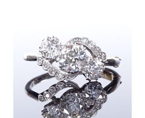 A platinum 3-stone diamond crossover ring, with diamond set shoulders, central stone approx 0.95ct, total diamond content app