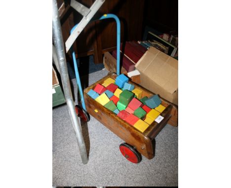 A VINTAGE TRI-ANG BABY WALKER AND WOODEN BLOCKS