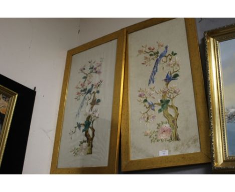 A PAIR OF TALL GILT FRAMED AND GLAZED VINTAGE NEEDLEWORKS DEPICTING BIRDS IN TREES 
