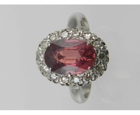 A platinum, ruby and diamond cluster ring, set large central stone surrounded by small diamonds, the shank stamped PLAT.