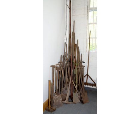 A COLLECTION OF VINTAGE GARDEN TOOLS, TO INCLUDE SPADES, HOES AND RAKES