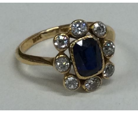 A sapphire and diamond oval cluster ring with rub over mount in 18 carat gold setting. Approx. 4 grams. Est. £300 - £400.