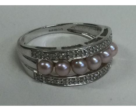 A 9 carat diamond and pearl set ring. Approx. 3 grams. Est. £20 - £30.