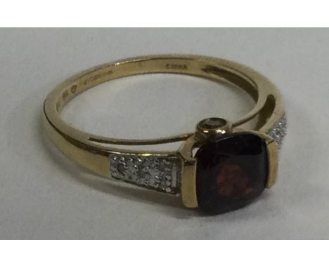 A small diamond and garnet ring with rub over mount. Approx. 2 grams. Est. £50 - £80.