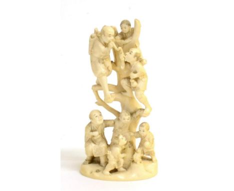 A Japanese Ivory Okimono as Men and Boys Climbing a Tree, Meiji period, two men smoking pipes, two children playing with a sq