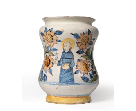 A Castelli Maiolica Albarello, 18th century, of dumbbell form, painted in colours with a saint amongst stylised foliage, 21cm