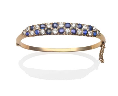 A Sapphire and Diamond Bangle, two rows of alternating round cut sapphires and old cut diamonds, in yellow claw settings abov