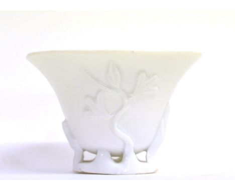 A Blanc de Chine Libation Cup, Kangxi, of ovoid form, moulded with flowering branches on a pierced and moulded base, 9.5cm wi