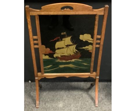 A 1930s Arts and Crafts oak firescreen, central glazed panel of a sailing ship, 101cm high, 63cm wide 