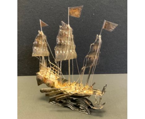 A mid 20th century Chinese model of a ship, carved wooden base, 18cm high, 17.5cm long. 