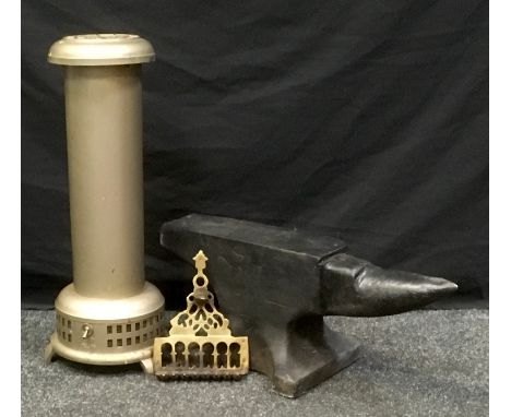 A reconstituted stone anvil;  vintage Belling heater;  a brass eight section oil burner. 