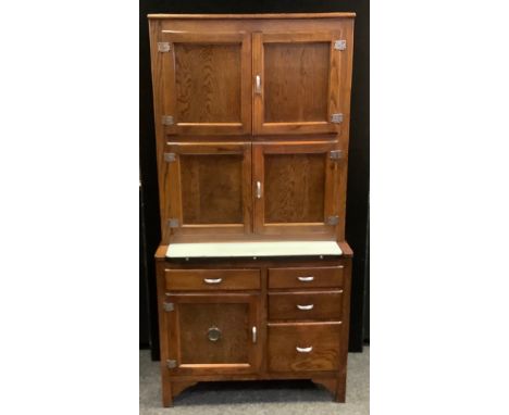 A 20th century oak kitchen utility unit, two pairs of cupboard doors, the projecting base with a enamel sliding tray, an arra