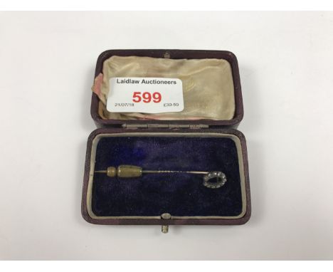 A cased Victorian diamond and yellow-metal stick pin, the terminal modelled as a horse-shoe and pellet-set with old-cut diamo