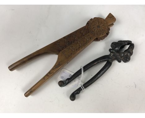 A Black Forest carved wooden nut cracker together with an antique cast-iron nut cracker