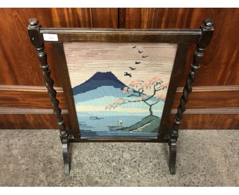 A 1930s oak framed fire screen with a hand-embroidered insert