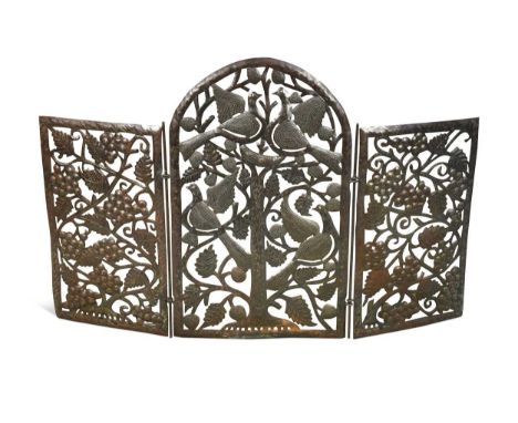 An Arts & Crafts style steel firescreen,  the three-fold design with hinged side panels, pierced and repoussé decorated with 