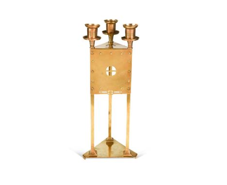 A Secessionist-style brass triform candlestick, with pierced cruciform decoration to the front panel, stamped 'JT' to undersi