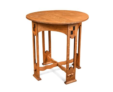 After M H Baillie Scott, an oak occasional table, the circular top raised on pierced silhouette supports each with a chequer 