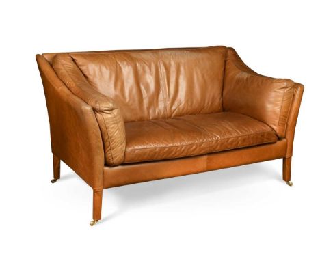 A Danish style two-seat brown leather sofa, raised on leather-clad square section legs and brass castors85 x 150 x 80cmIn goo