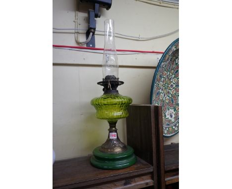 An antique brass and pottery oil lamp,&nbsp;with green glass reservoir, height excluding chimney 34cm.&nbsp; 