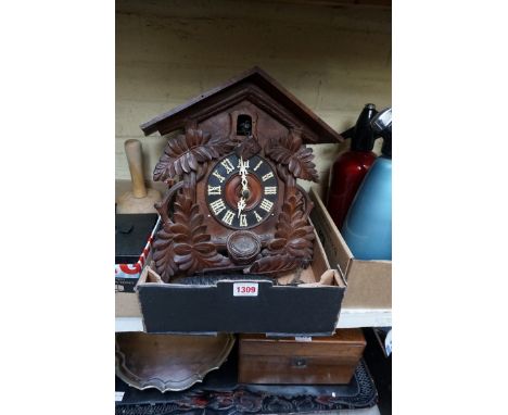 A late 19th century Continental carved wood cuckoo clock,&nbsp;34cm high, with carved wood pendulum and pair of pine cone wei