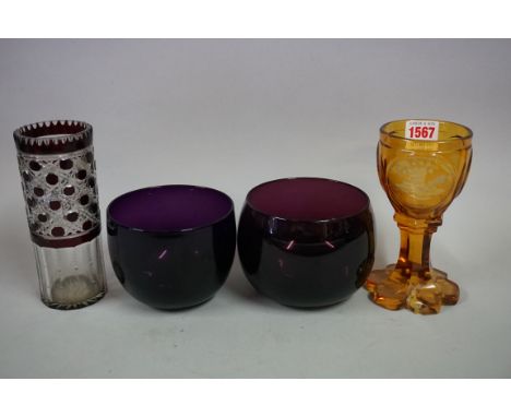 A Bohemian amber glass spa goblet,&nbsp;16.5cm high, (chip to foot rim); together with two amethyst glass finger bowls; and a