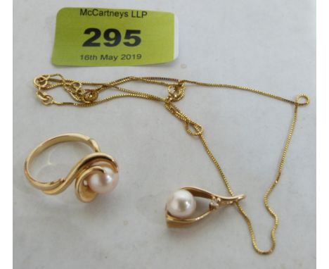 A yellow metal pearl and white stone wishbone pendants and 14ct chain with a yellow metal pearl ring. Both marked '14k' Italy