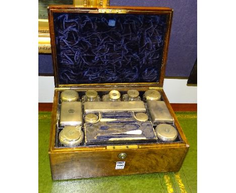 A Victorian silver topped travelling vanity set in a rosewood and brass mounted box, the hinged top monogrammed, enclosing tw