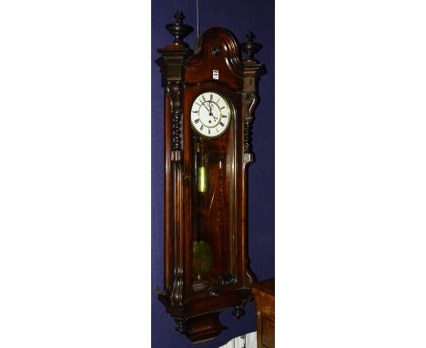 A Victorian rosewood cased wall clock circa 1880, with shaped top above glazed door enclosing white enamel dial with subsidia