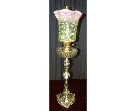 A large Victorian plated and cut glass oil lamp, with coloured frilly rim glass shade, the plated column with ornate foliate 