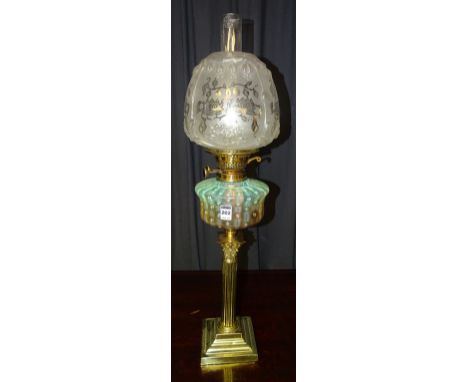 A brass Corinthian style oil lamp circa early 20th century, with glass funnel and shade above Duplex burner and vaseline glas