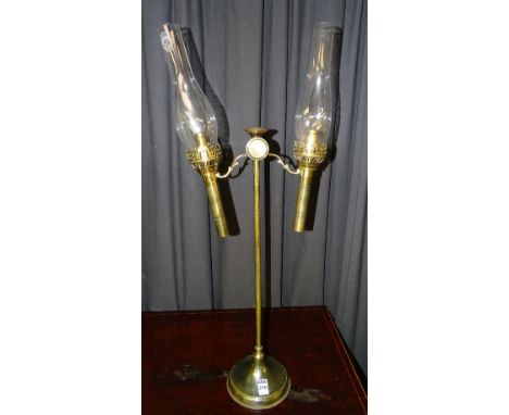 A gilt metal oil lamp, the twin branches with glass funnels, marked for Kamenz Crystal, raised on plain stem and circular foo