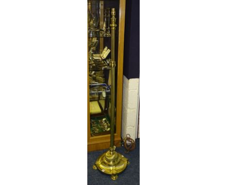 A late Victorian brass floor lamp, raised on circular platform base with ornate foot, fitted for electricity, 151cm high