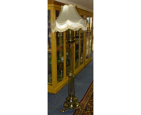 A Victorian French brass floor standing oil lamp with later shade, the oil lamp reservoir above column and circular platform 