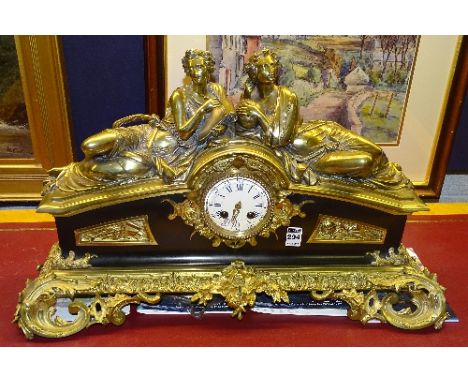 A French Victorian brass and gilt metal mantel clock, with two brass Roman style reclining females to the top, etched Thuydid