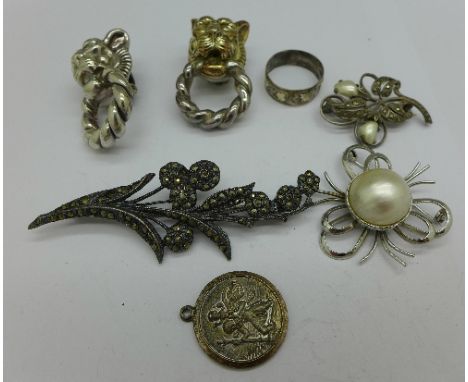 Silver including marcasite brooches, a silver and pearl brooch, a gold applied ring, a St. Christopher and a pair of lion ear