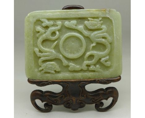 A Chinese carved jade plaque, a/f, with carved stand, 137mm x 101mm