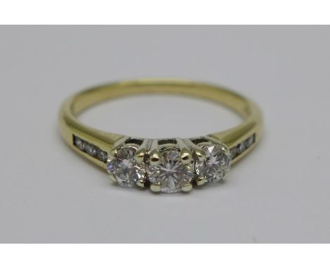 A 9ct gold, three stone diamond ring with diamond set shoulders, 2.3g, N